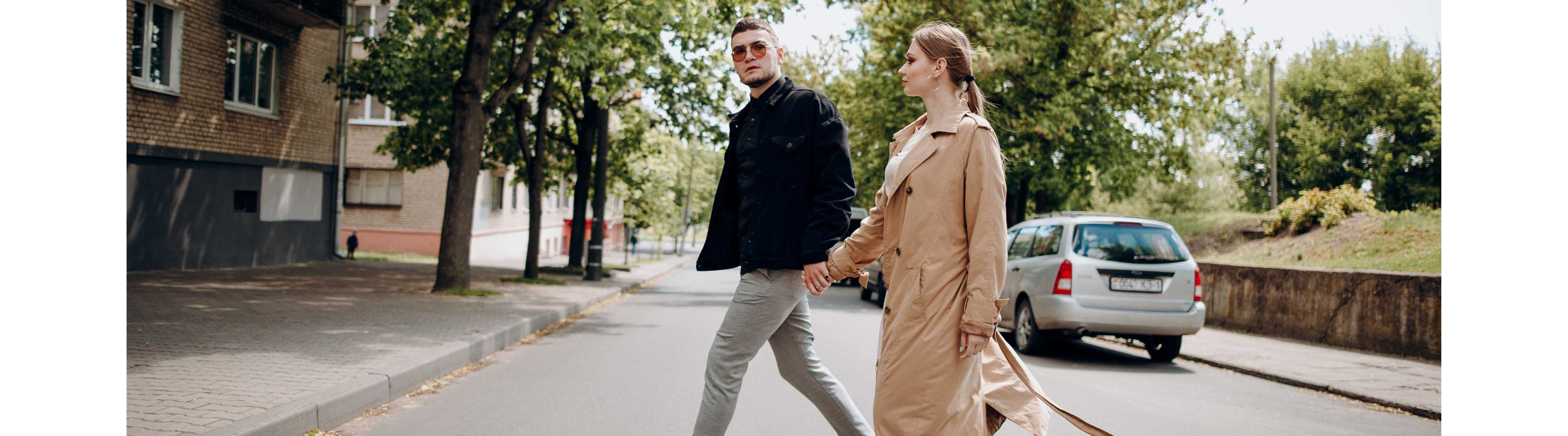 Man and woman walk along side each other on a road. 